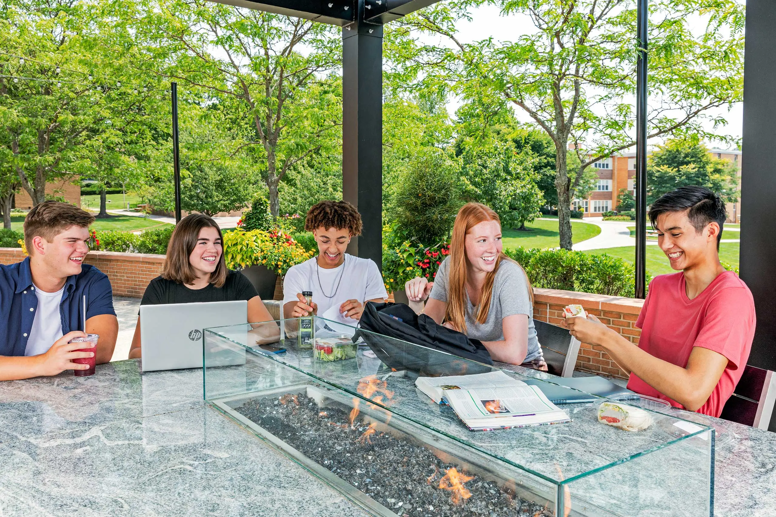 Students happily sitting around a table outside